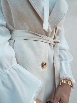 Close-up of a fashionable beige coat with a button detail in Baghdad, Iraq.