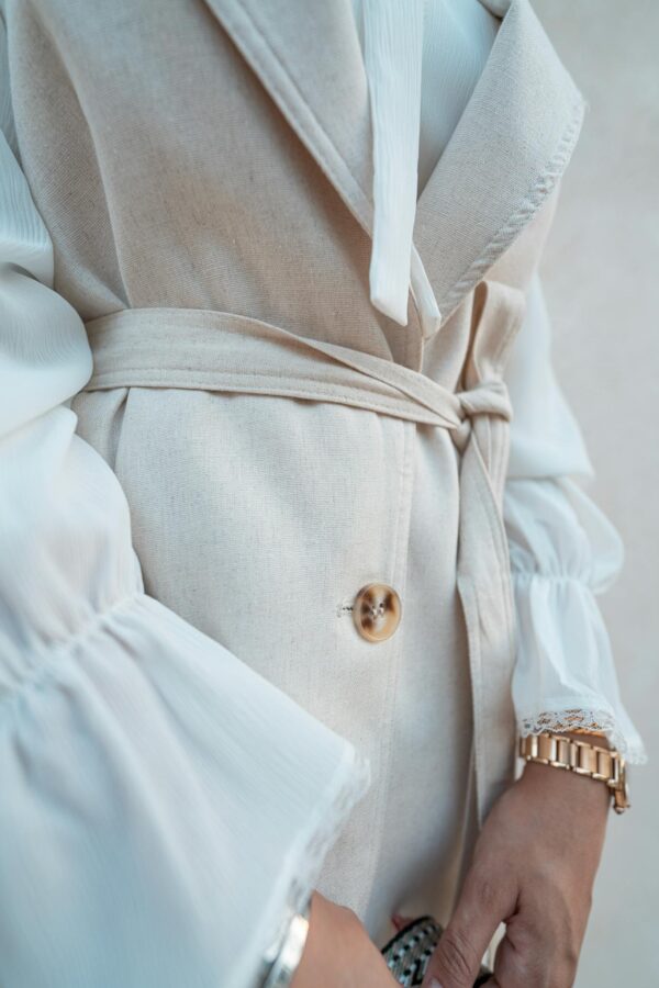 Close-up of a fashionable beige coat with a button detail in Baghdad, Iraq.