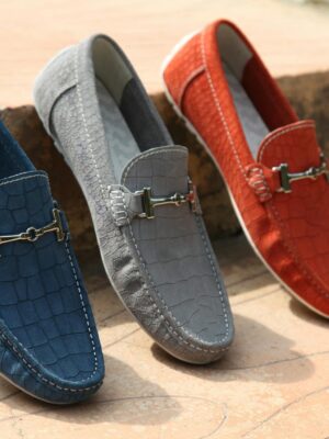 Three colorful leather loafers displayed outdoors showcasing style and elegance.