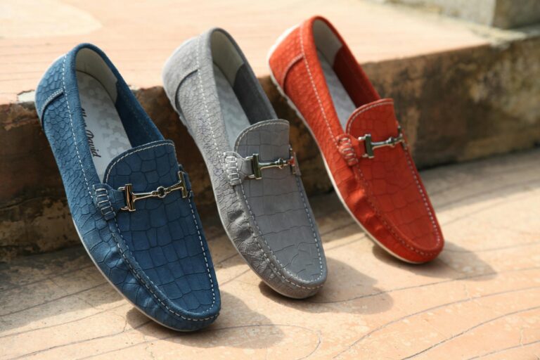 Three colorful leather loafers displayed outdoors showcasing style and elegance.